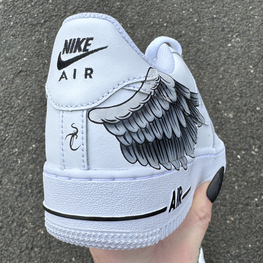 Nike Air Force 1 custom avec aile d’ange peinte à la main sur les côtés externes – design artistique et symbolique. Vu arrière côté