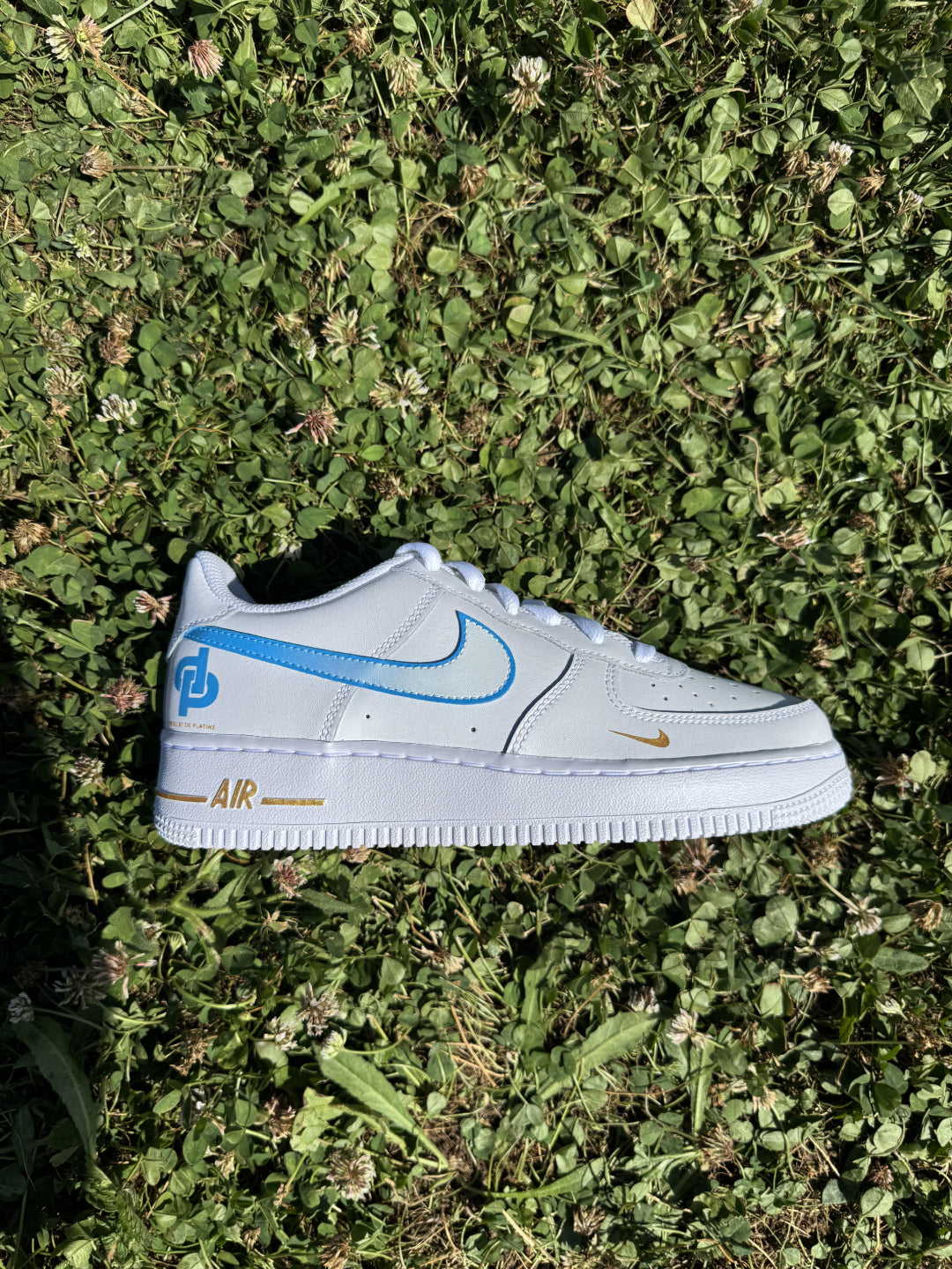 Zapatilla derecha de Nike Air Force 1 custom con diseño artístico dorado y referencias al álbum “D’or et de Platine” de JUL.