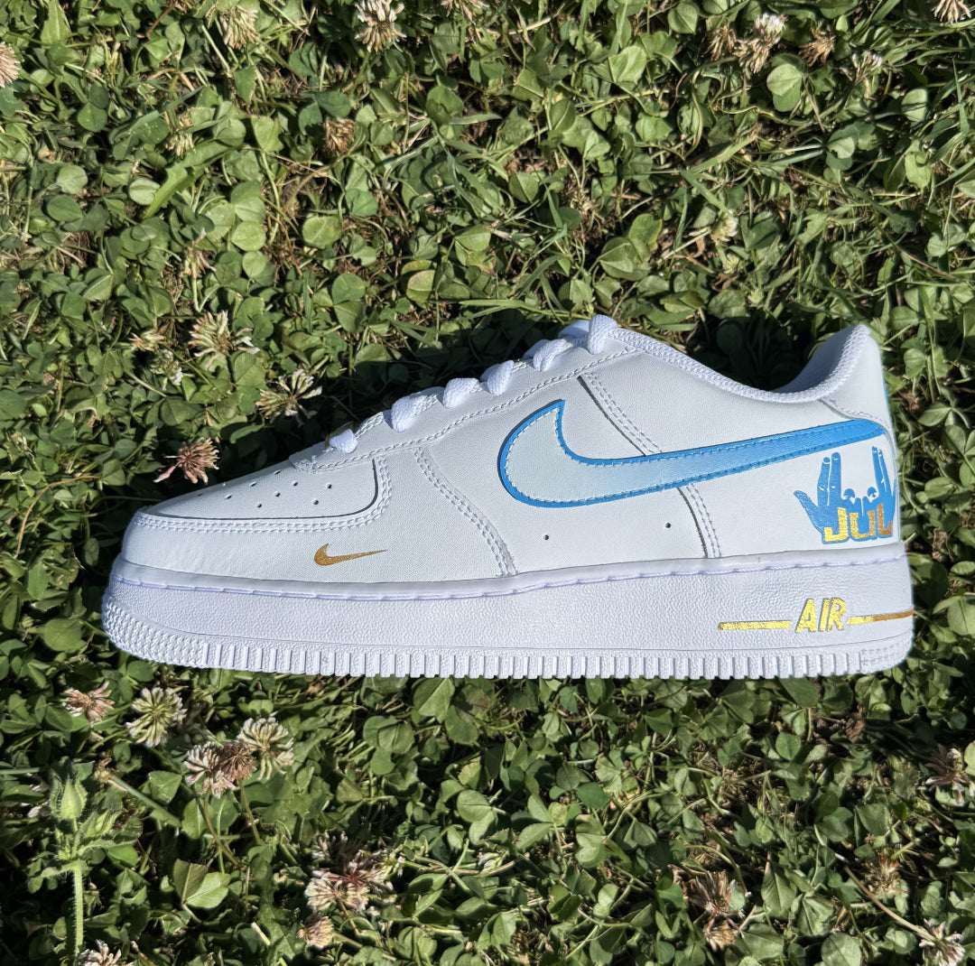Zapatilla izquierda de Nike Air Force 1 personalizada con ilustraciones y toques plateados inspirados en el universo musical de JUL.