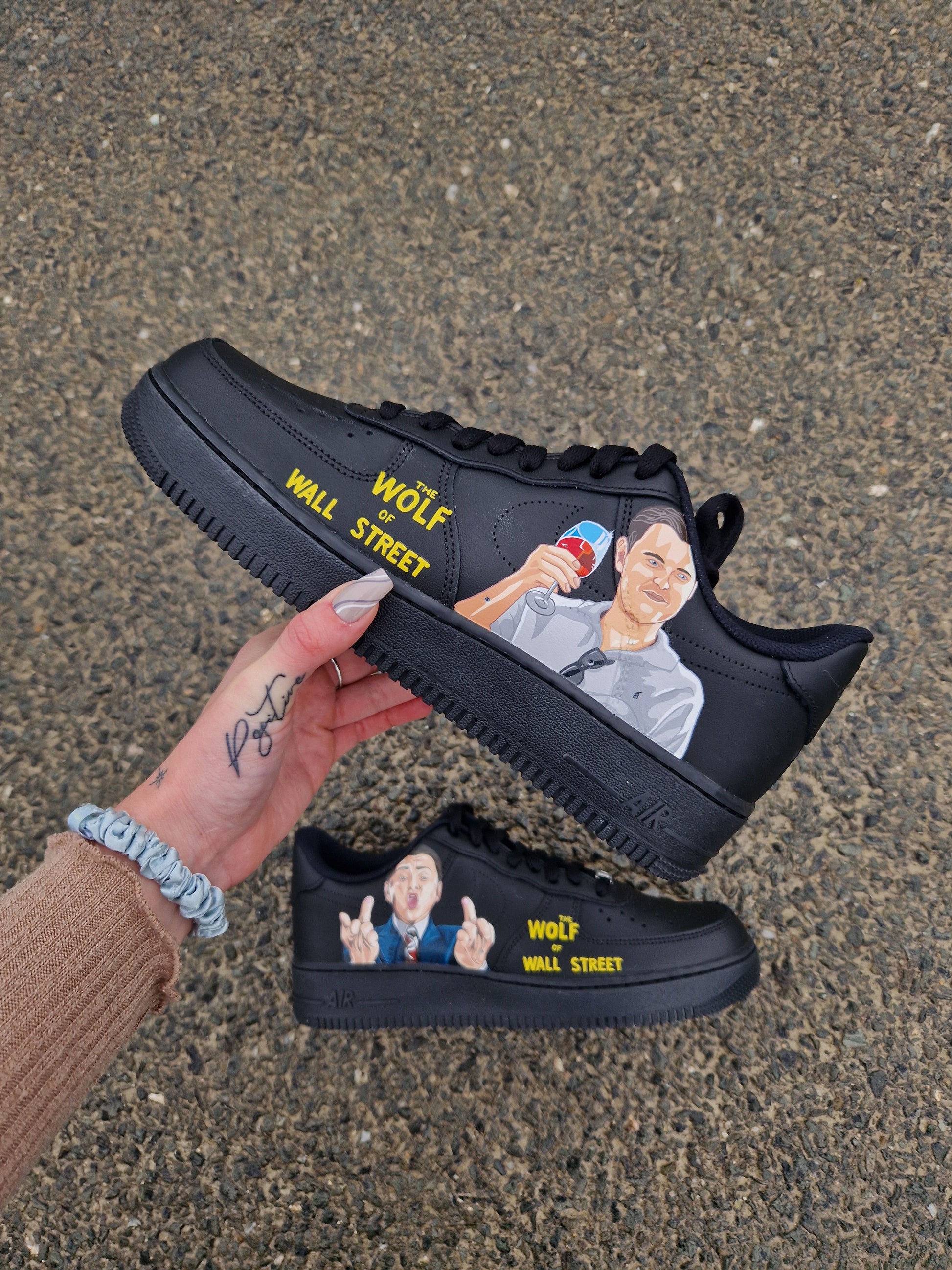 Zapatilla Nike Air Force 1 negra con ilustración pintada a mano inspirada en otra escena de "The Wolf of Wall Street", estilo realista y elegante.