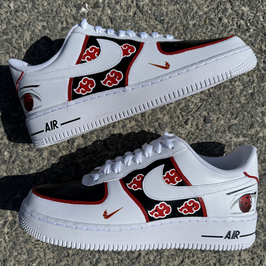 Nike Air Force 1 personalizadas Akatsuki con nubes rojas sobre fondo negro, contornos rojos y el Sharingan de Itachi pintado en la parte trasera.
