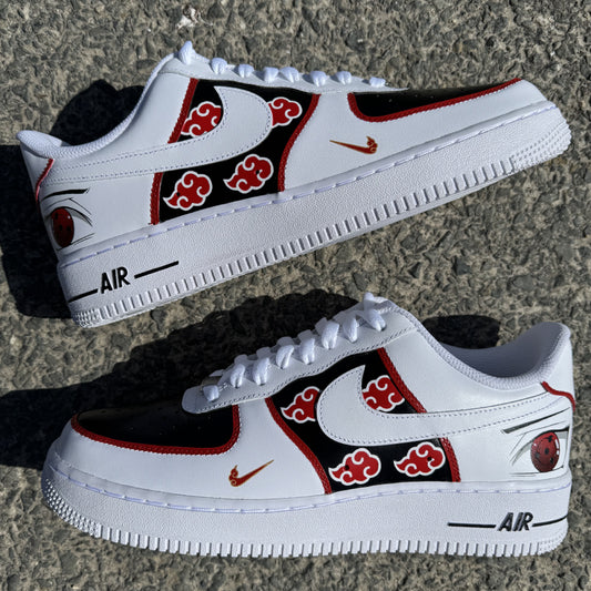 Nike Air Force 1 personalizadas Akatsuki con nubes rojas sobre fondo negro, contornos rojos y el Sharingan de Itachi pintado en la parte trasera.