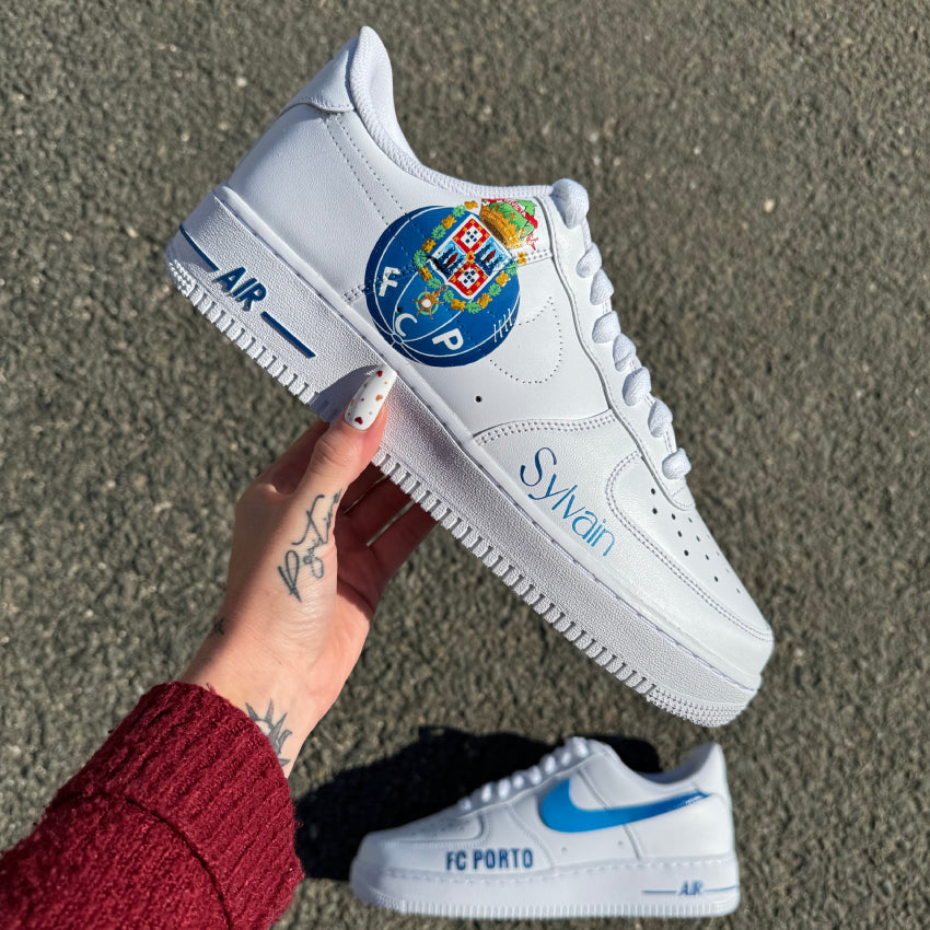 Nike Air Force 1 custom avec logo FC Porto peint à la main sur une chaussure, swoosh dégradé bleu et inscription “FC PORTO” sur l’autre.