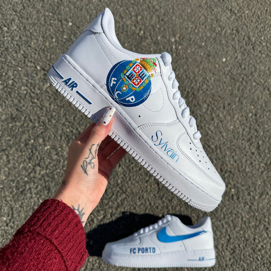 Nike Air Force 1 custom avec logo FC Porto peint à la main sur une chaussure, swoosh dégradé bleu et inscription “FC PORTO” sur l’autre.