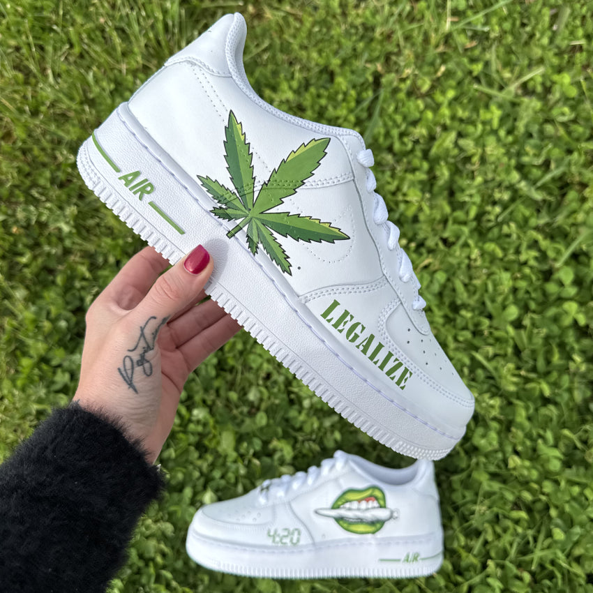 Nike Air Force 1 customisée avec une feuille de cannabis peinte sur le côté et le mot "LEGALIZE" à l’avant de la chaussure.