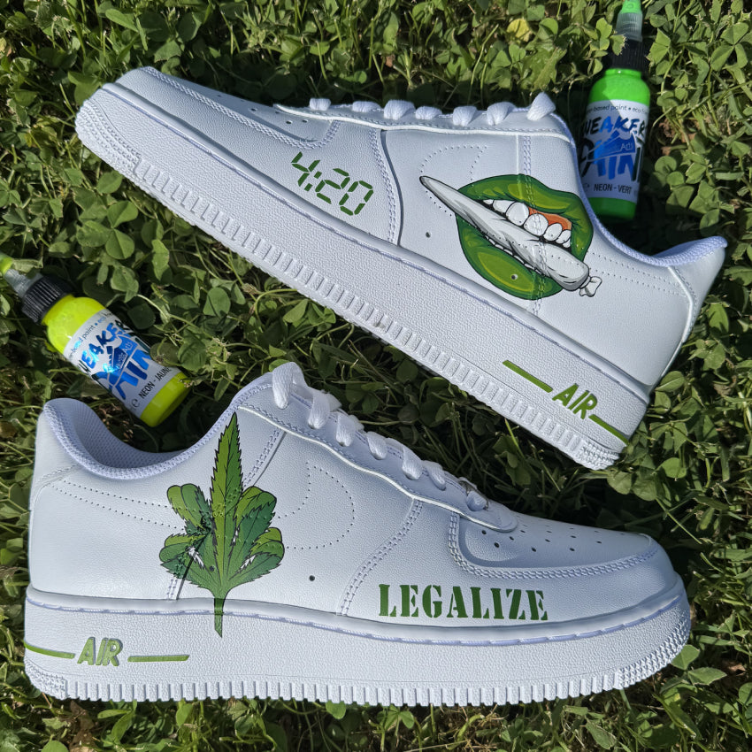 Nike Air Force 1 customisées avec peinture Sneakarts, représentant une feuille de cannabis sur les côtés et "LEGALIZE" à l’avant.