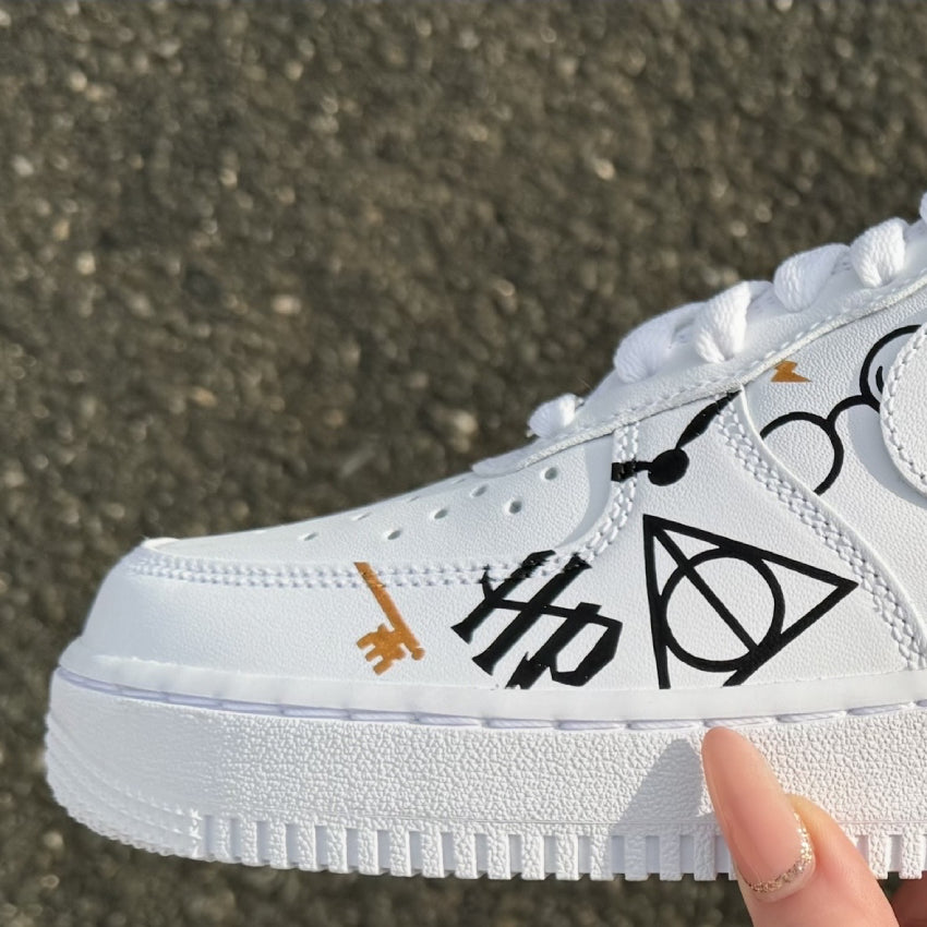 Nike Air Force 1 vue sur l'arrière custom avec symboles Harry Potter peints en noir, rouge et doré. Vue sur l'avant de la chaussure.