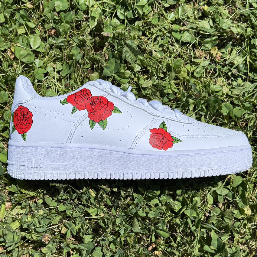 Nike Air Force 1 custom avec trois roses rouges peintes sur le côté extérieur de chaque chaussure.