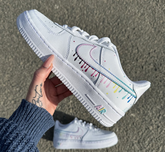 Par de Nike Air Force 1 personalizadas a mano con diseño de gotas pastel multicolor sobre los swooshes, estilo artístico y moderno.