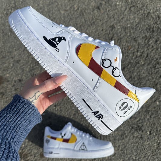 Nike Air Force 1 custom pied gauche avec swoosh rouge et or pour Gryffondor, et logos noirs inspirés de l’univers Harry Potter