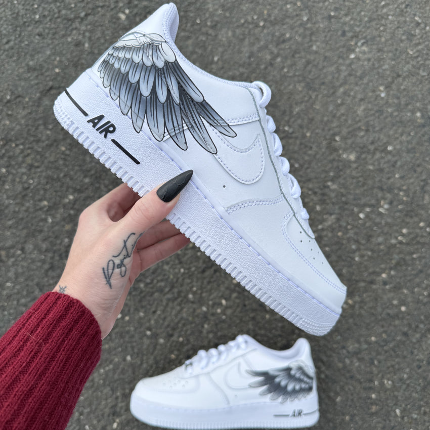 Nike Air Force 1 custom avec aile d’ange peinte à la main sur les côtés externes – design artistique et symbolique.