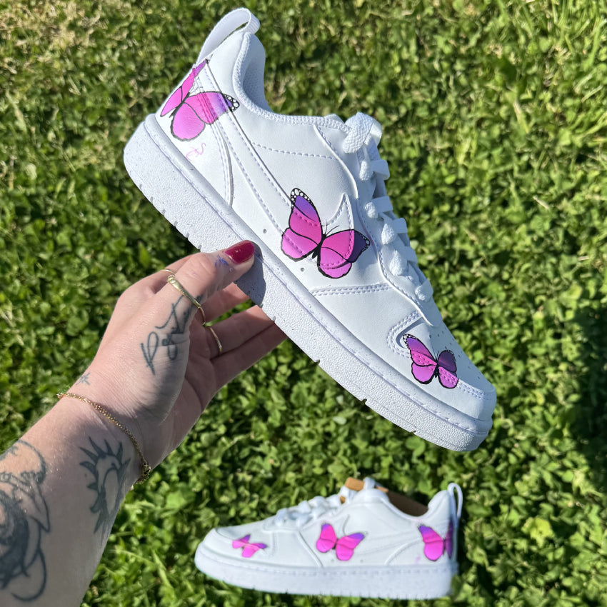 Nike Court Vision Low custom avec trois papillons violets peints sur le côté extérieur de chaque chaussure.