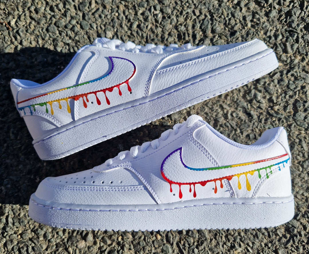 Par de Nike Air Force 1 personalizadas a mano con diseño de gotas multicolor sobre los logos Nike, estilo artístico y colorido.